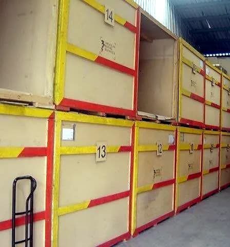 Cajones de madera numerados con marcas rojas y amarillas en bodega