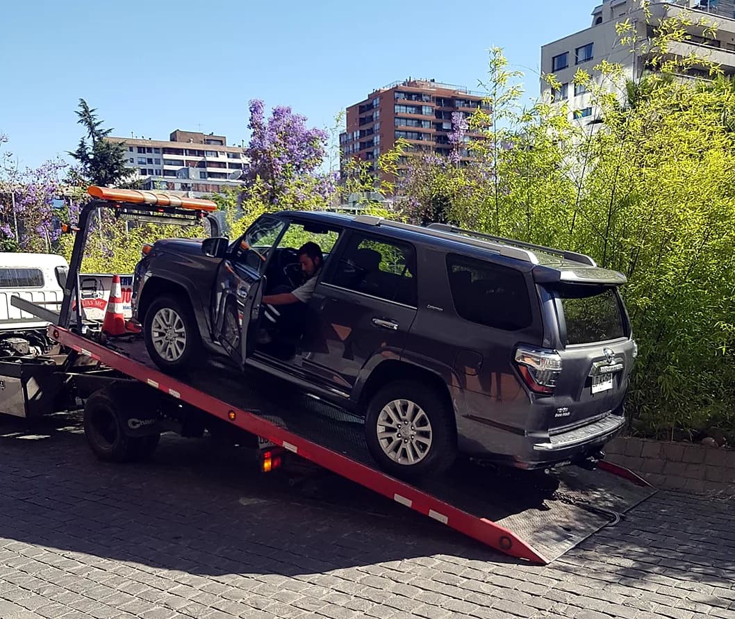 Camioneta subiendo a una grúa plataforma para su traslado